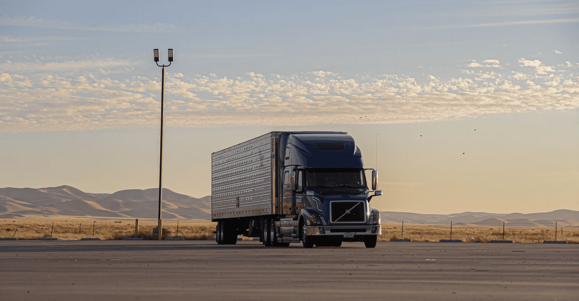 A commercial truck parked against a wide rural landscape